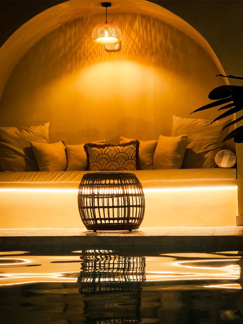 Nicho del arco iluminado de noche, reflejado en la piscina